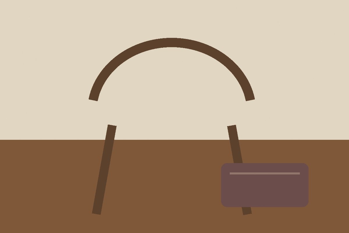 A plain wooden stool beside a folded blanket